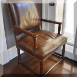 F25. Leather and wood armchair with nailhead trim. 41”h x 25”w x 24”d 
